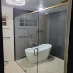 Modern bathroom with a freestanding tub and glass shower enclosure.