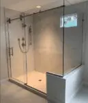 Modern glass shower enclosure with chrome fixtures in a bathroom.