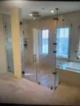 Modern glass shower enclosure in a spacious bathroom.